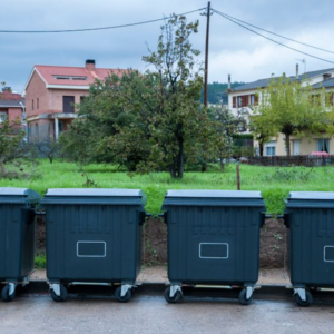 Row of dumpsters lined up in a DC Washington neighborhood, representing junk removal vs dumpster rental options.