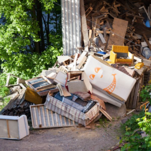 A large pile of discarded furniture and wood waste, showing common household items that can be recycled.