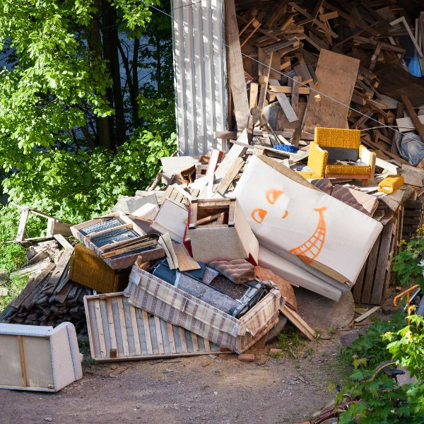 A large pile of discarded furniture and wood waste, showing common household items that can be recycled.